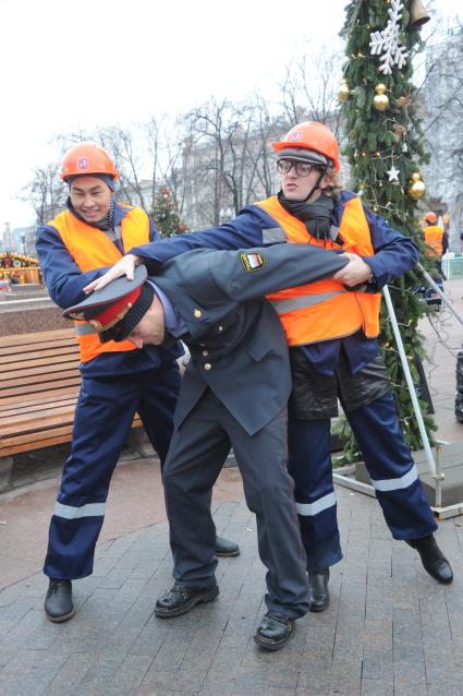 Московские строители провели новогодний флэшмоб на Пушкинской площади. На снимке: строители и полицейский.