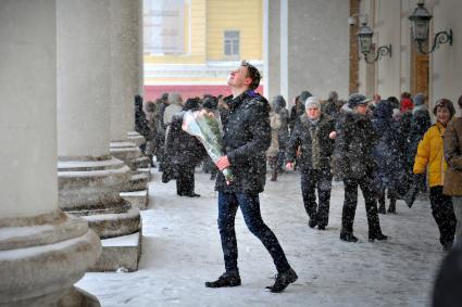 Снегопад в Москве. На снимке: молодой человек с букетом роз.