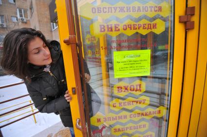 Дирекция магазина `Мед` по адресу: г. Москва, ул. 1-я Аэропортовская, 6 , ввела санкции президенту США, Барак Обама лишен прав входа в магазин. На снимке: девушка читает объявление на двери магазина.