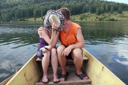 Юноша и девушка целуются на лодке.