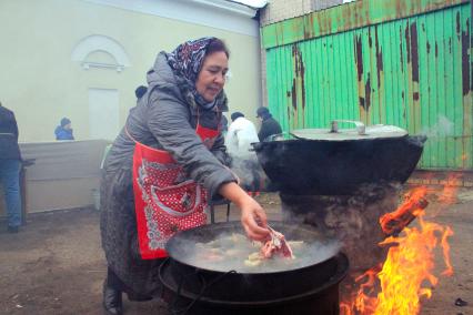 Праздник Курбан-Байрам. Женщина готовит еду на открытом огне.