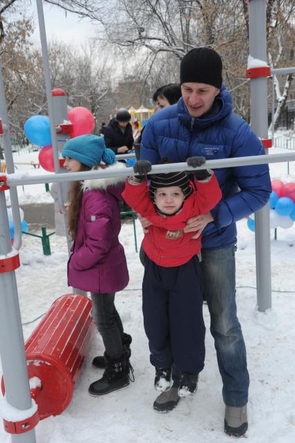 На спортивной площадке в Савеловском районе прошел конкурс `Подтянись больше главы управы`. На снимке: ребенок подтягивается на турнике.