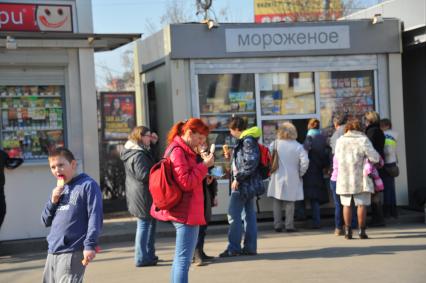 Температурный рекорд в Москве достиг 19 градусов. На снимке: люди покупает мороженое в ларьке.