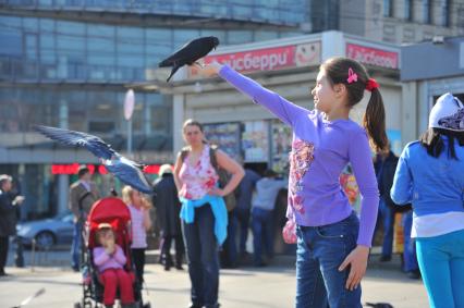 Температурный рекорд в Москве достиг 19 градусов. На снимке: девочка кормит голубей с рук у метро `Баррикадная`.