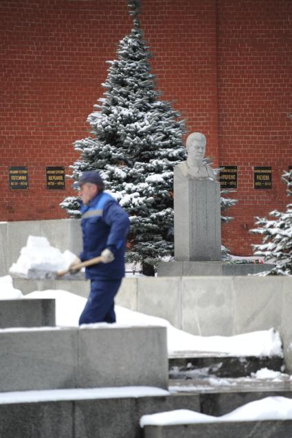 Некрополь у Кремлевской стены. Могила и памятник Сталину. На снимке: рабочий убирает снег.