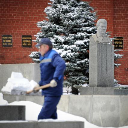 Некрополь у Кремлевской стены. Могила и памятник Сталину. На снимке: рабочий убирает снег.