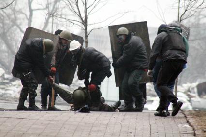 Представители оппозиции волокут раненного протестующего.