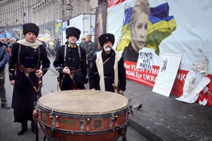 Казаки на площади Независимости в Киеве на фоне плаката с изображением украинского политика Юлии Тимошенко.