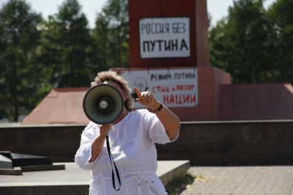 Белоленточники в Красноярске. Женщина с мегафоном на митинге. Сзади антиправительственные плакаты.