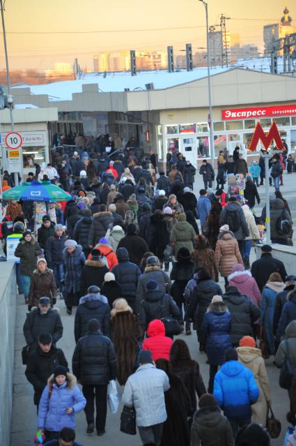 Толпа людей выходит из московского метрополитена на станции `Курская`.