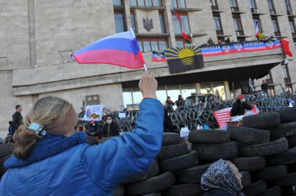 Ситуация в Донецке. Здание Донецкой областной администрации, захваченное противниками новой власти. На снимке: активистка держит российский флаг.