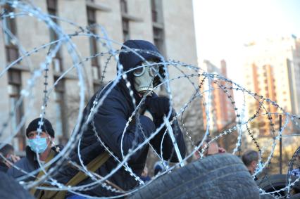 Ситуация в Донецке. Здание Донецкой областной администрации, захваченное противниками новой власти. На снимке: активист в противогазе на баррикадах.