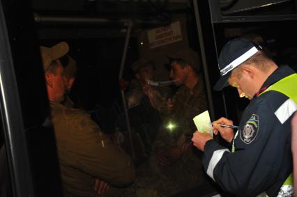 Ситуация в Донецке. У военкомата местные жители перекрыли дорогу автобусу с украинскими номерами, в котором находились военные с оружием без  опознавательных знаков. На снимке: милиционер переписывает данные водителя автобуса.