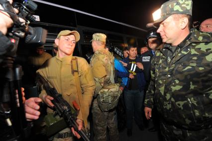 Ситуация в Донецке. У военкомата местные жители перекрыли дорогу автобусу с украинскими номерами, в котором находились военные с оружием без опознавательных знаков. На снимке: военные выходят из автобуса и направляются в здание военкомата.