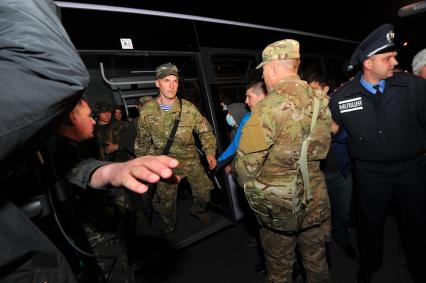 Ситуация в Донецке. У военкомата местные жители перекрыли дорогу автобусу с украинскими номерами, в котором находились военные с оружием без  опознавательных знаков. На снимке: военные выходят из автобуса и направляются в здание военкомата.