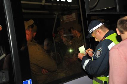 Ситуация в Донецке. У военкомата местные жители перекрыли дорогу автобусу с украинскими номерами, в котором находились военные с оружием без  опознавательных знаков. На снимке: милиционер переписывает данные водителя автобуса.