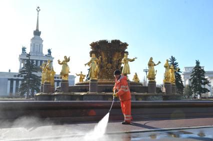 ВВЦ. На снимке: рабочий поливает асфальт у фонтана `Дружба народов`