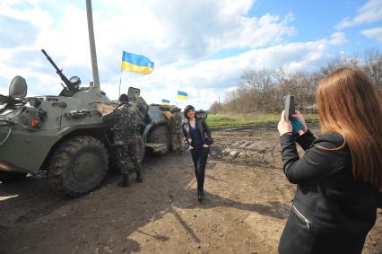 Ситуация в Изюме. Вооруженные украинские военные у въезда в город. На снимке: местные жительницы фотографируются на фоне военной техники.