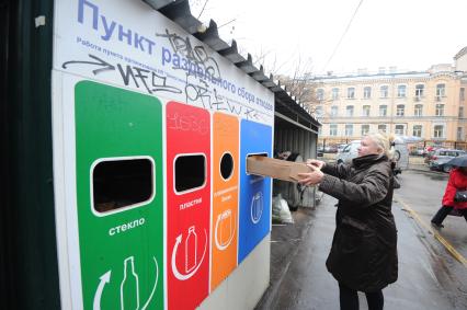 Пятницкая улица. Пункт раздельного сбора и сортировки мусора. На снимке: женщина выбрасывает мусор.