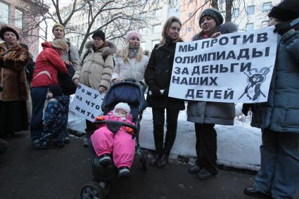 Митинг беременных женщин у Министерства здравоохранения и социального развития РФ против нового порядка выплаты пособий в декретном отпуске. На снимке: женщина держит плакат `Мы против Олимпиады за деньги наших детей`.