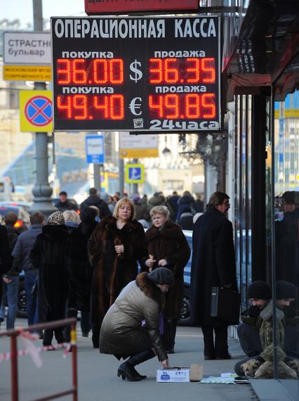 Операционная касса на Тверской улице. На снимке: табло с курсом валюты и женщина подает милостыню.