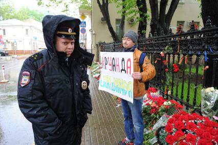 Акция памяти по погибшим в результате военных столкновений на Украине. Возложение цветов к зданию посольства Украины в Москве. На снимке: мужчина с плакатом.