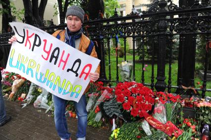 Акция памяти по погибшим в результате военных столкновений на Украине. Возложение цветов к зданию посольства Украины в Москве. На снимке: мужчина с плакатом.