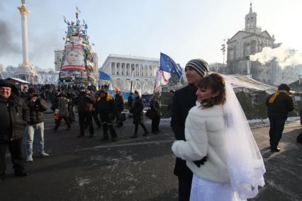 Беспорядки в Киеве. На снимке: молодожены фотографируются на фоне баррикад активистов Евромайдана на площади Независимости (Незалежности).