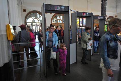 На станции `Добрынинская` московского метро  установили рамки металлоискателя. На снимке: пассажиры проходят через рамки металлоискателя.