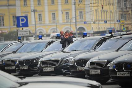 Служебные автомобили с проблесковым маячком на парковке у Государственной думы.