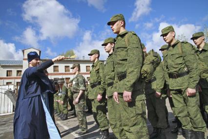 Новобранцы около призывного пункта. Священник окропляет новобранцев.