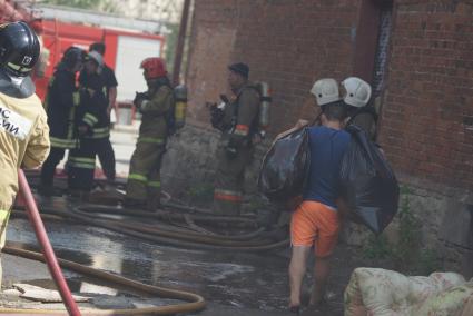 Мужчина выносит вещи уцелевшие во время пожара в доме на Вайнера 70 в Екатеринбурге