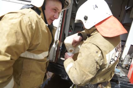 Пожарные наливают воду из канистры в стакан чтобы попить во время пожара в Екатеринбурге на Вайнера 70