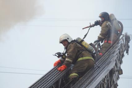 Пожарные на выдвижной лестнице во время пожара в Екатеринбурге на Вайнера 70