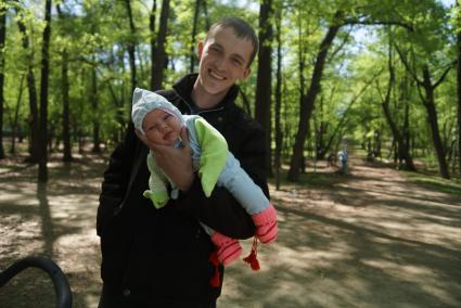 Мужчина держит на одной руке маленького ребенка