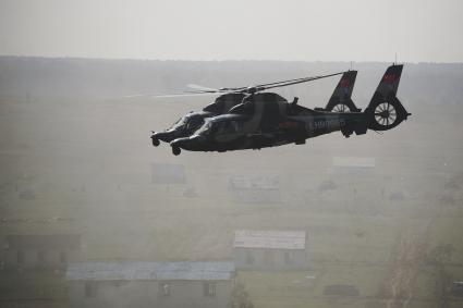 Звено китайских боевых вертолетов z-9 летят над полем во время проведения Российско-Китайских учений Мирная миссия 2013 на полигоне в Чебаркуле