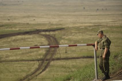 Российский военный стоит на посту облокотившись на шлакбаум на полигоне в Чебаркуле