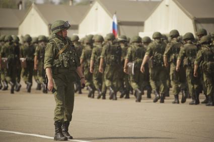 колонна российских солдат и офицер у палаточного лагеря во время проведения Российско-Китайских учений Мирная миссия 2013 на полигоне в Чебаркуле