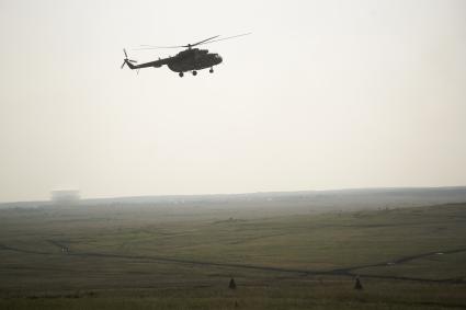 Военный транспортный вертолет ми-8 во время полета над полигоном  в Чебаркуле