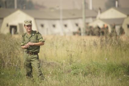 Российский военный стоит в поле на полигоне в Чебаркуле у полевого палаточного лагеря во время проведения Российско-Китайских учений Мирная миссия 2013 на полигоне в Чебаркуле