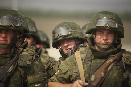 Российский солдат выглядывает из-за плеча сослуживца в строю  во время проведения Российско-Китайских учений Мирная миссия 2013 на полигоне в Чебаркуле