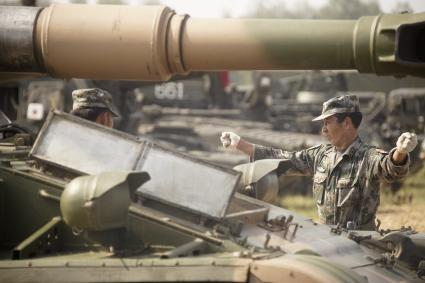 Китайский военный регулирует движение бронетехники во время проведения Российско-Китайских учений Мирная миссия 2013 на полигоне в Чебаркуле