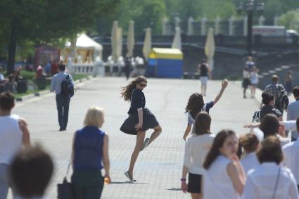 Выпускницытанкуют на набережной во время празднования последнего звонка в школах