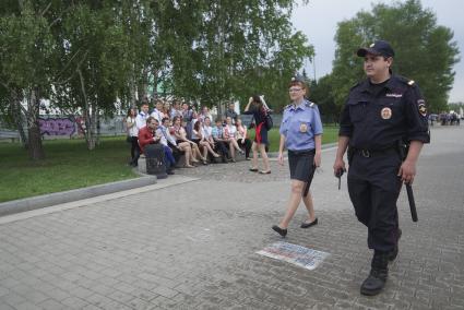 Полицейские проходят мимо группы выпускников в день последнего звонка