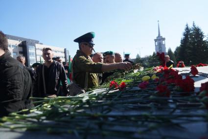 мужчина в зеленомберете возлагает цветы к памятнику \"черный тюльпан\" в Екатеринбурге во время дня пограничника