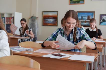 Школьница достает иг пакета бланки для сдачи ЕГЭ
