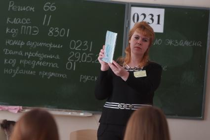 Учитель демонстрирует ученикам пакет бланков ЕГЭ и его целостность