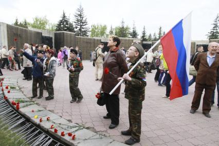 Празднование годовщины Победы в Барнауле. Дети с цветами и флагами у мемориала.