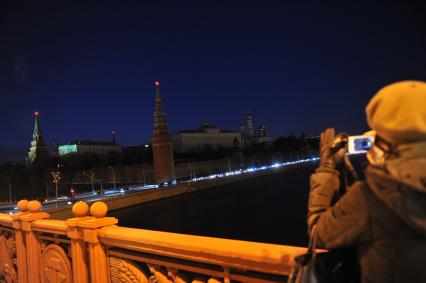 Экологическая акция WWF `Час Земли` в Москве. На снимке: девушка фотографирует  вид на Московский Кремль после отключения подсветки.