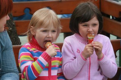 Традиционный фестиваль мороженого в парке `Сокольники`. На снимке: девочки едят мороженое.